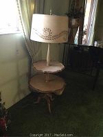 Full view of vintage two-tier round table lamp showing two wooden tiers and the lamp base and shade.
