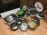 Full lot view showing pots, pans, baking pans, crockpot, cutlery, and kitchen tools on the floor.
