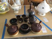 Overview of the lot showing sake set, soup bowls, black cup, and decorative brass item.