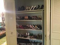 Photo showing white shelving units with 4 shelves holding various women's dress shoes size 6 with heels in different styles and colors including black, white, pink, beige, metallic gold, and purple.