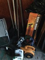 Photo of garden tools including rakes, hedge trimmer box, handheld leaf blower, and a smaller handheld tool.