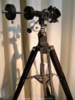 Full view of vintage telescope tripod stand showing wooden legs, metal braces, and adjustment mechanisms.