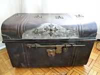 Angled front view of closed chest showing dome lid, decorative cutouts and exterior finish