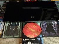 Samsung BD-D6500 Blu-ray 3D Player placed atop DVDs visible below including Total Recall and The Matrix series.