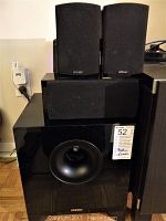 Front of subwoofer cabinet with center channel speaker on top and two satellite speakers above