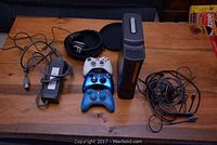Full lot overview showing modified Xbox 360 console, power adapter, three wireless controllers (white, blue, and dark blue), wired headset, and cables.