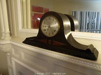 Front view of antique Waterbury Rosedale mantel clock on white mantel.