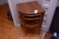 Table and matching chair nested together against wall