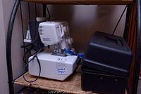 Janome serger machine on shelf beside black carrying case