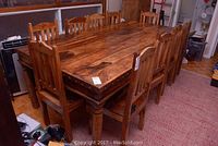 Ten teak chairs arranged around table showing overall set