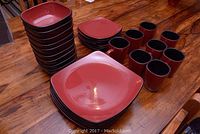 Overview of stacked square plates, bowls, side plates, and mugs on wooden surface