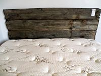 Front view of barn board headboard against wall with mattress in front