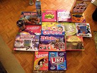 Photo of various board games including Monopoly Disney Pixar edition, Scrabble, Battleship, Risk, Settlers of Catan, Yahtzee, and others.