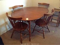 Round maple dining table with one 18-inch leaf inserted, showing top view with chairs around it (not included).