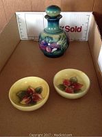 Moorcroft vase with stopper and two dishes, showing entire set in a carton box.