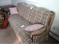 Full view of plaid patterned Sklar-Peppler sofa showing seat, back cushions, and two pink pillows.