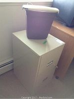 Photo of beige 2-drawer filing cabinet with paper shredder placed on top, showing overall cabinet and shredder size and shape.