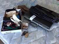 Wide view of all items in the lot showing various handbags, gloves, jewelry, briefcase, and travel bag.