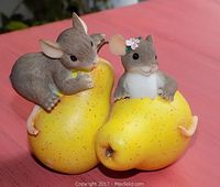 Front view of Fitz & Floyd Charming Tails resin mouse figurine featuring two gray mice interacting with yellow pears, placed on pink surface.