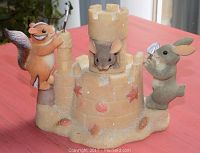Front side view of Fitz & Floyd Charming Tails Building Our Dreams Together figurine featuring squirrel and rabbit figures at either side of a sandcastle with a mouse peeking out the tower.
