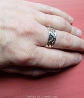Ring worn on finger showing size and design of zig zag pattern with polished silver finish.