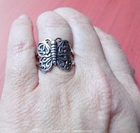 Close-up photo of the sterling silver butterfly ring worn on a person's finger, showing the open winged butterfly design and the ring's approximate size.