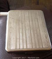 Top front view showing vertical grooved pattern and etched leaf border on the cigarette case.
