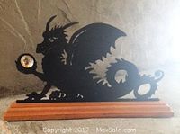 Side view of the wooden dragon silhouette figurine with crystal orb on a wooden base, showing the detailing and the orb held by the dragon's paw.