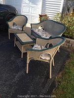 Two armchairs, loveseat and side table arranged outdoors