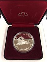 Reverse side of 1986 Canadian proof silver dollar depicting steam locomotive with text commemorating Vancouver Railroad 1886-1986.