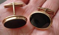 Front view of pair showing oval black onyx stones in gold bezels
