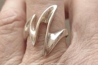 Close-up image of sterling silver zigzag ring worn on finger, showing design and size