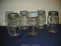 Six clear glass Crown fruit jars arranged in two rows showing fronts and metal lids.