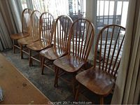 All six chairs lined up in a row by a window