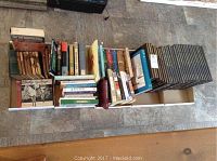 Top wide angle view showing multiple trays filled with various books, including a full set of uniform dark covered Time-Life series on the right and assorted vintage and modern books on the left and center.