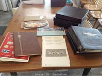 Wide view of all albums, binders, and coin display on a table.