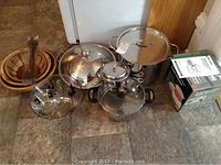 Group shot of all items on floor: bowls, servers, chip and dip set, cookware, steamer box