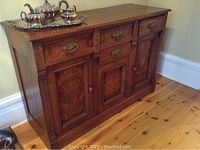 Full front view of walnut server sideboard showcasing overall design, drawer and door layout