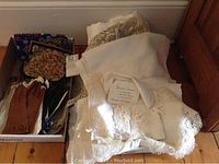 Box containing ladies evening bags, leather gloves, and scarves with various floral prints.