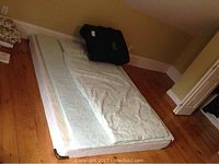 Three mattress toppers laid on floor with one carry bag
