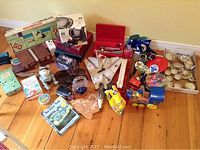 Assorted kids toys, board games, a wooden toy train, and various miscellaneous items arranged on the floor.