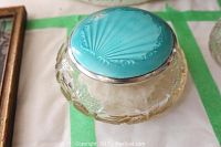 Full view of cut crystal jar with silver and enamel lid closed