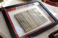 Full front view of framed manuscript leaf on tabletop with visible #37 sticker