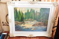 Framed oil painting showing a river rapids scene with a forest background.
