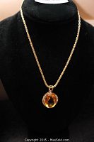 Full view of necklace and pendant displayed on a black bust