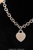 Close-up of heart pendant and chain on black display