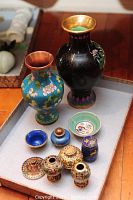 Overview of nine pieces including two vases, bowls, and lidded containers showing enamel patterns and colors.