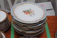 Stack of 6 dessert plates showing floral design, blue border, and gold rim.