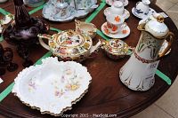 Image showing Sadler tea pot, cream and sugar set, Limoges chocolate pot, Royal Crown Derby bowls, and floral porcelain dish