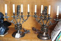 Pair of vintage metal candelabras with five candle holders and lion figurines at the top, showing overall size and appearance.